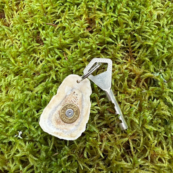 Luinen avaimenperä sarvikiekosta kiväärin hylsyllä.